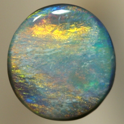 SOLID BLACK OPAL Golden fire of red and copper over a green - blue background